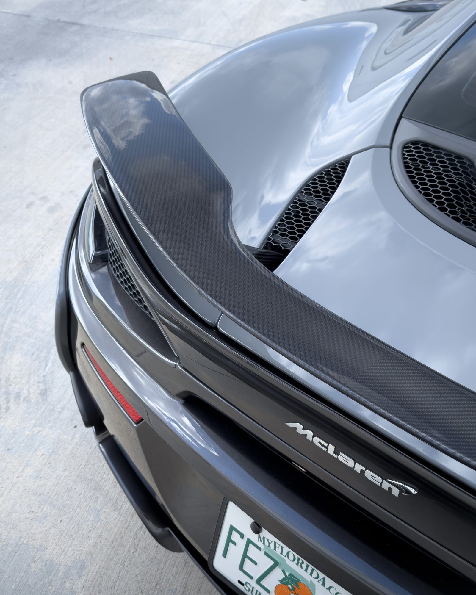 Carbon-fiber rear wing and engine cover on a McLaren finished by Restyle Miami